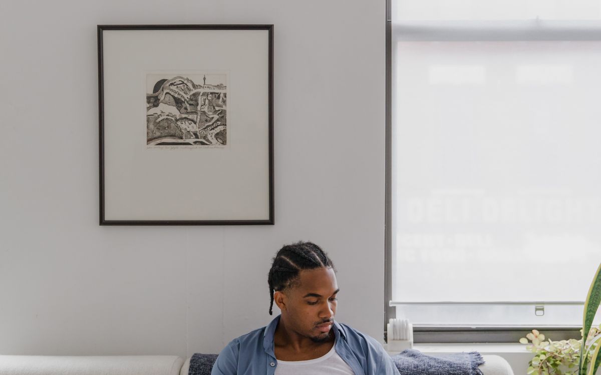 A person using a laptop on a sofa at home